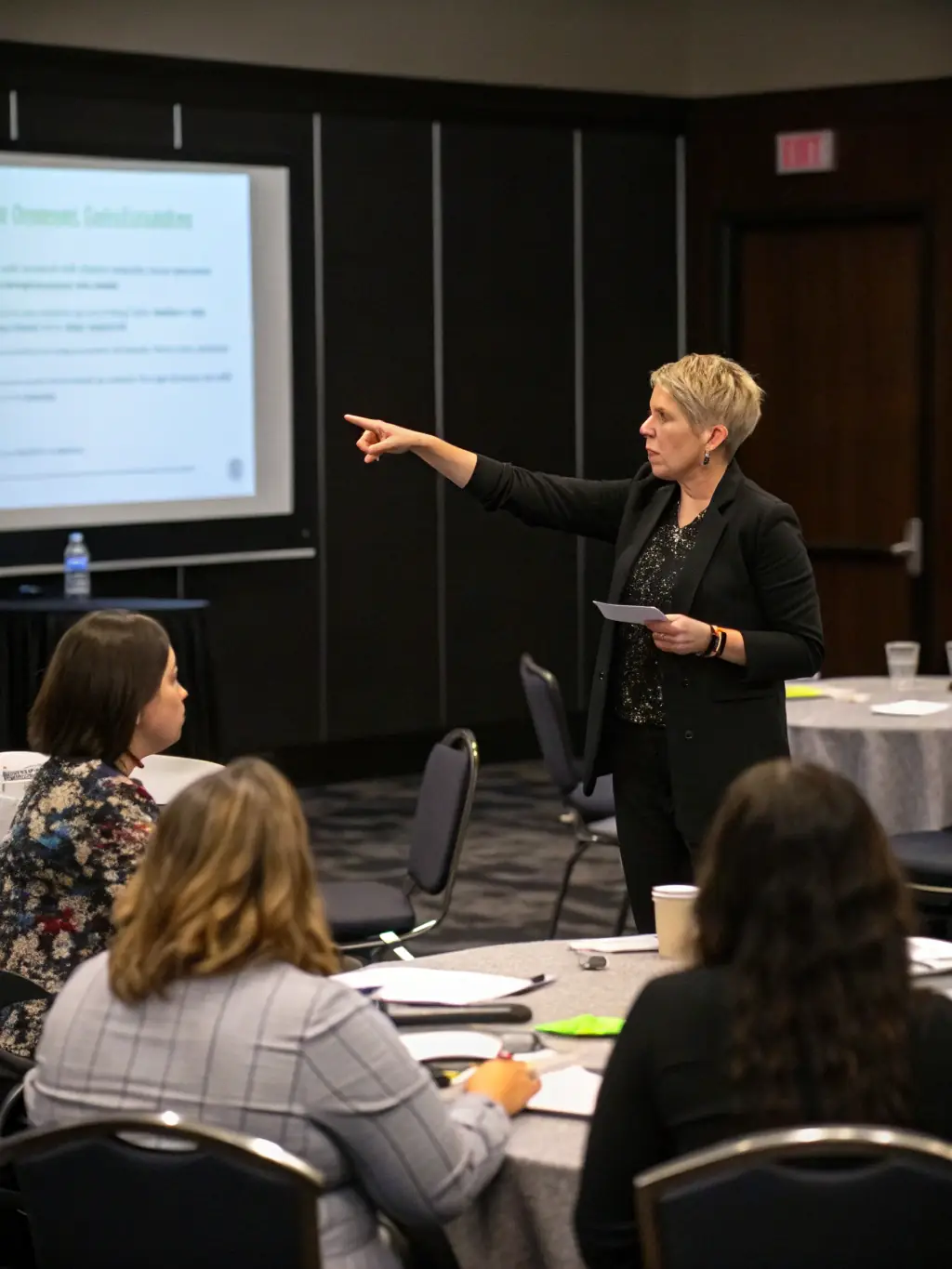 A professional image of a coach giving a motivational speech to a large audience at a seminar in a modern conference hall.